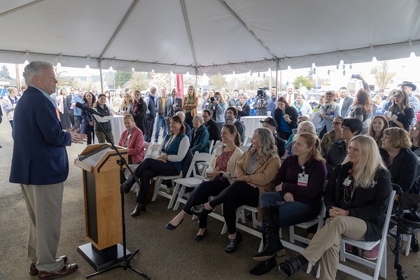 Lane Shetterly, past-chairman, Board of Trustees, Salem Health Hospitals and Clinics, stands at a podium speaking to a large group under a tent at the ribbon cutting event for the new outpatient clinic building in Dallas on March 20, 2024.