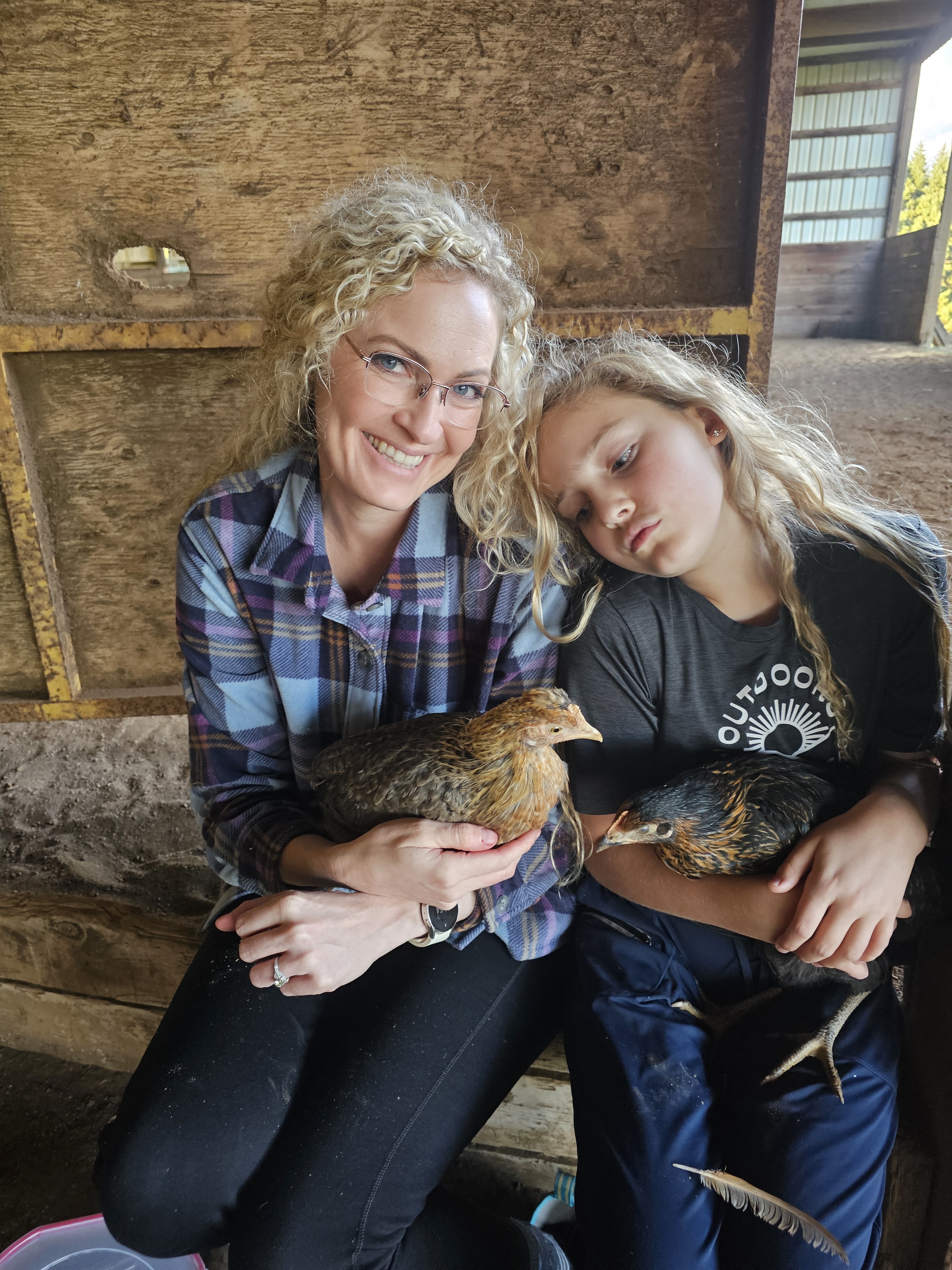 webber_4 Sarah Webber, MD, holds chickens with her daughter in a barn.