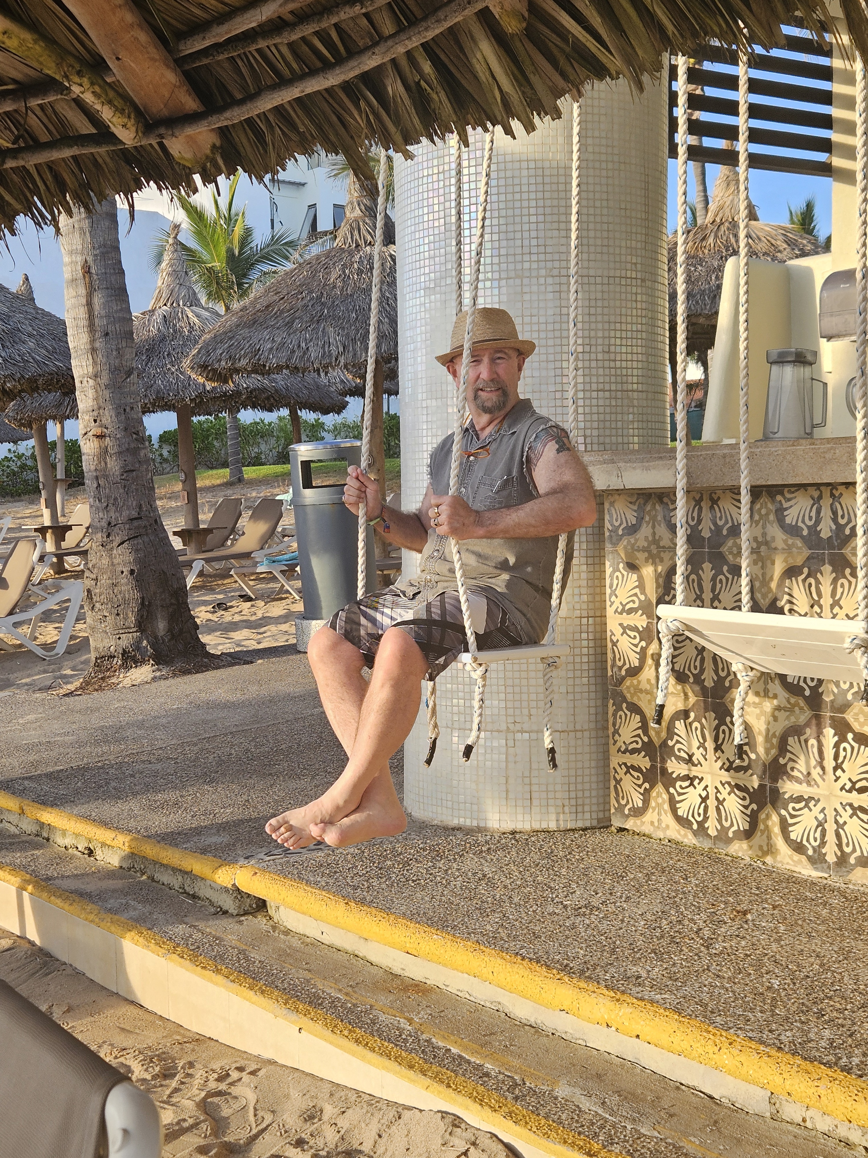 Dr. Collada sits on a swing.