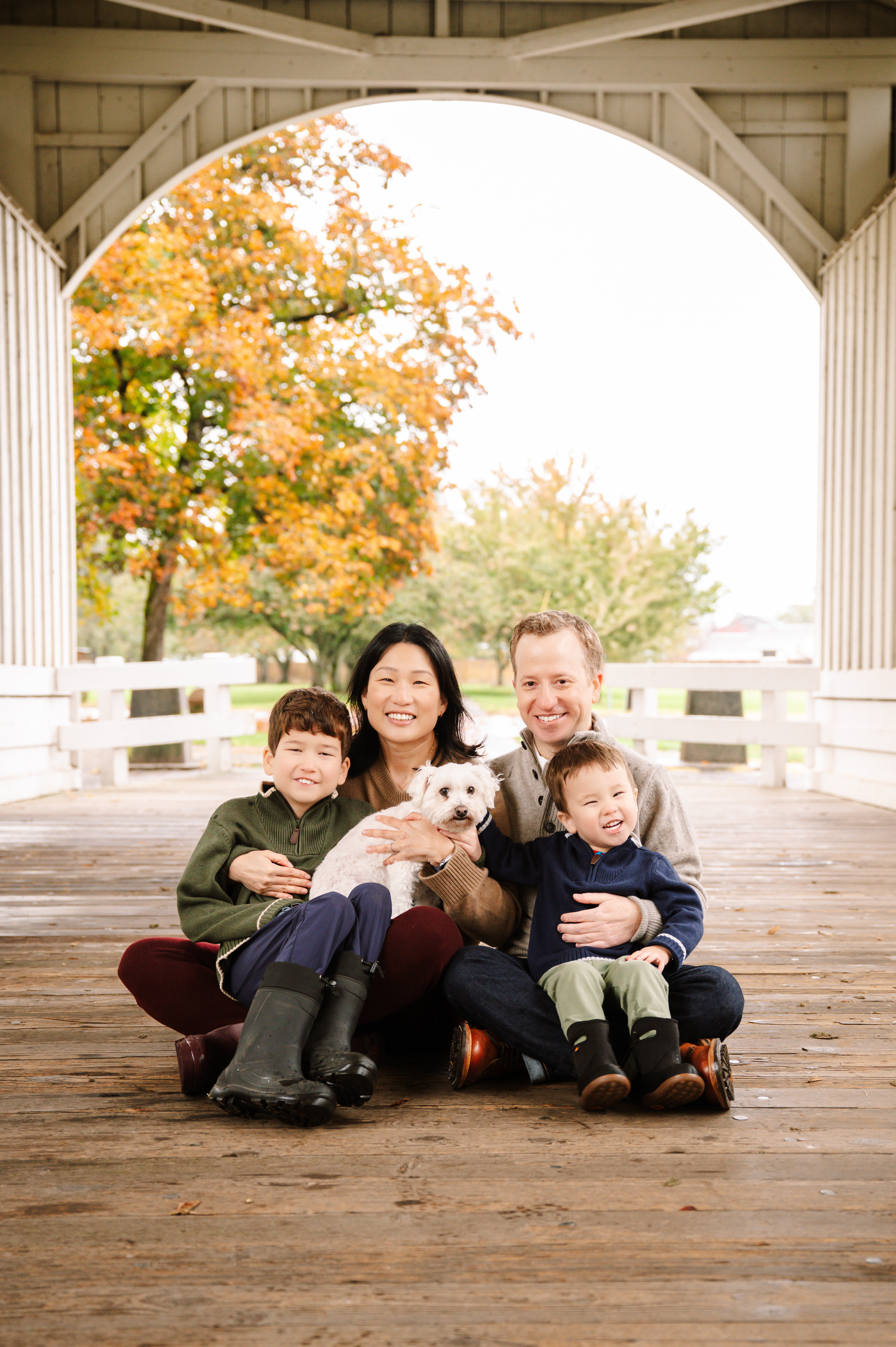 Matt Egalka, MD, poses with his family on a covered bridge.