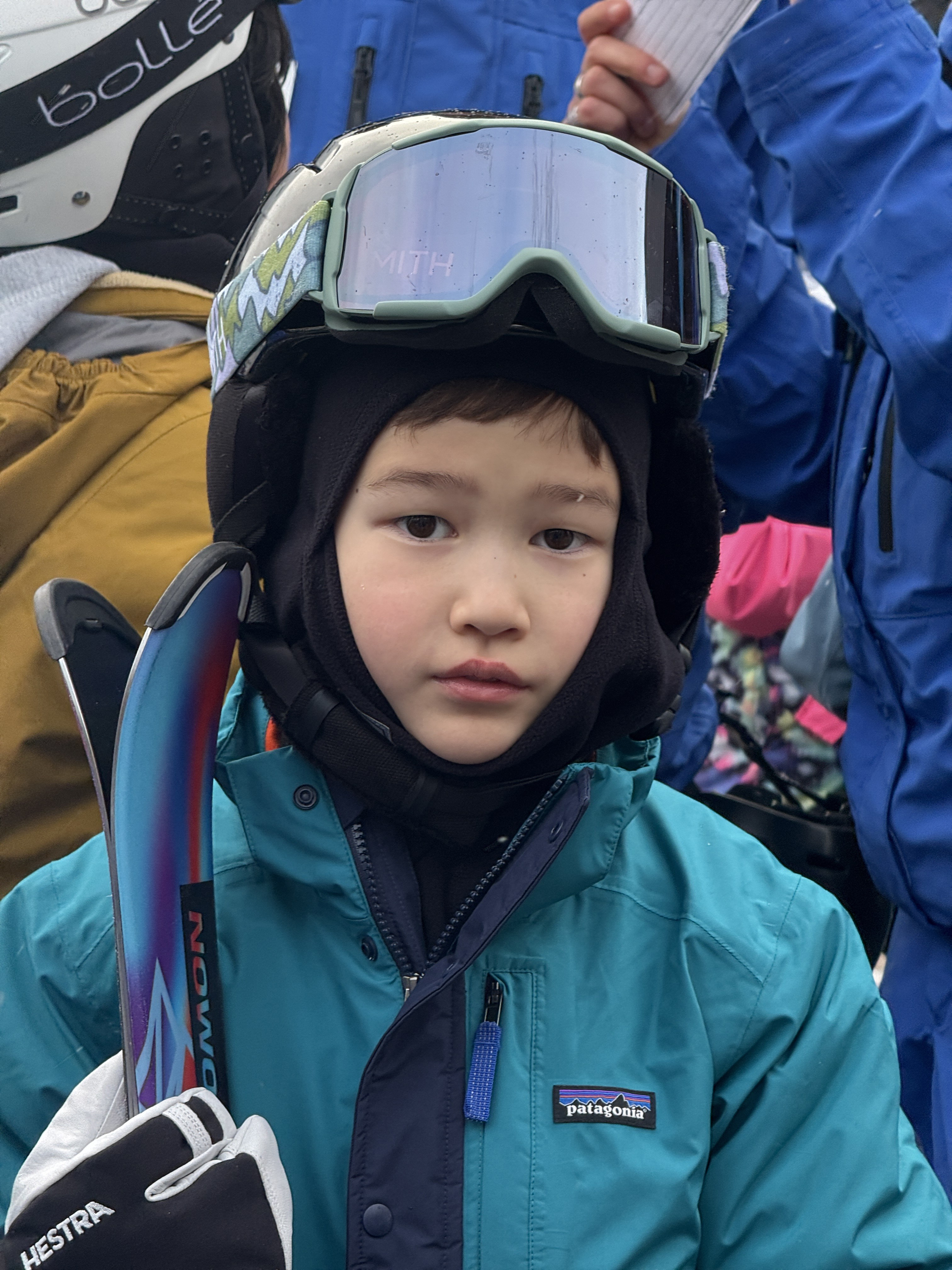 A boy poses in ski gear in winter.