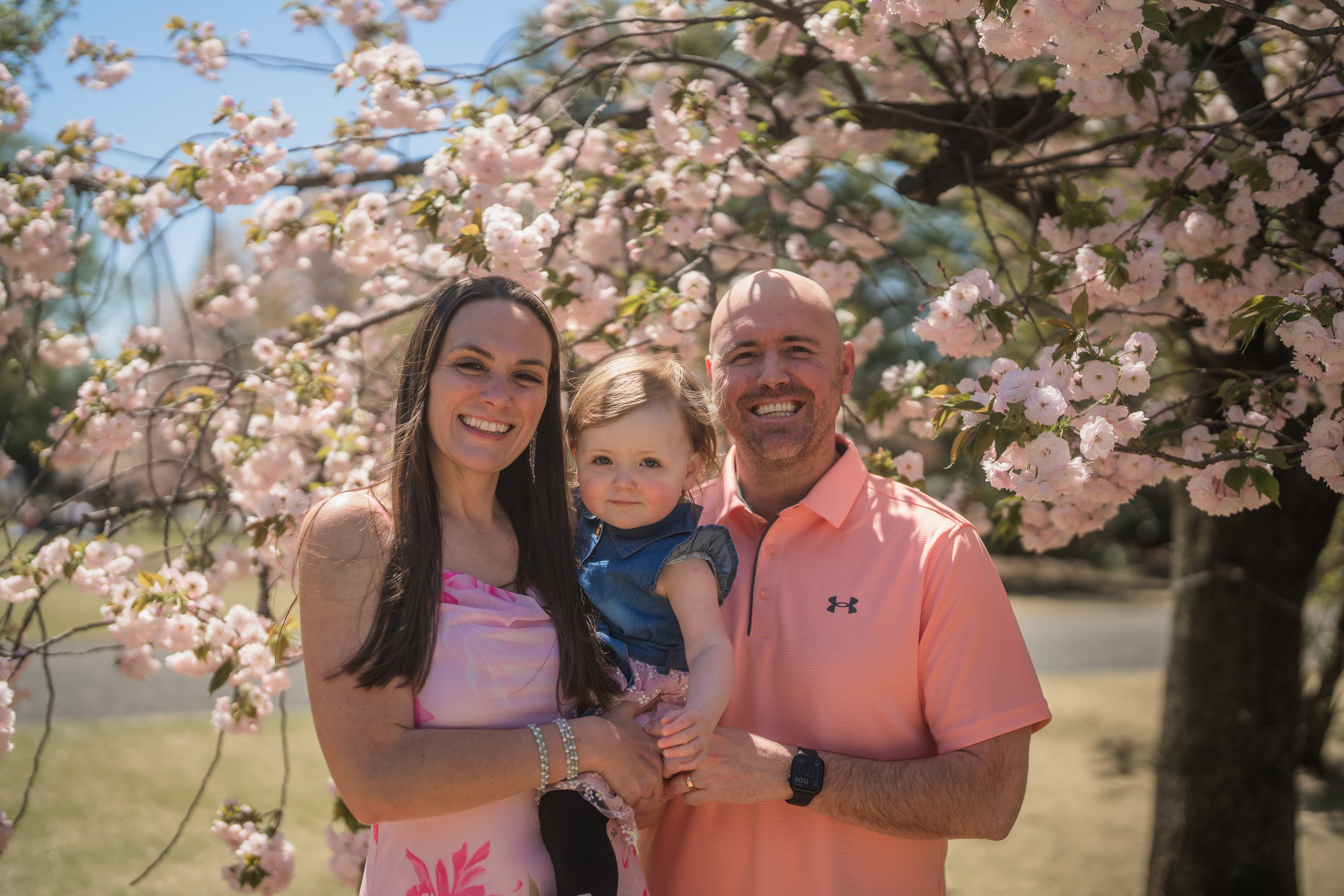 Dr. Meier with her husband and toddler beneath a blossoming tree.