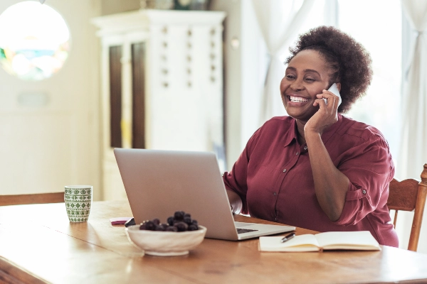 Woman using a computer and talking on the phone