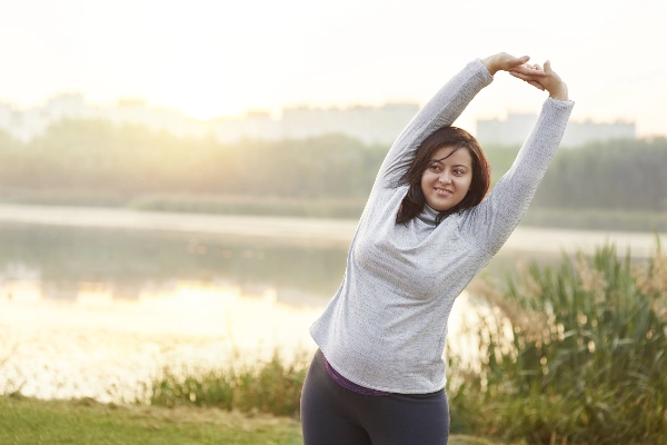 Woman stretching outside near a lake