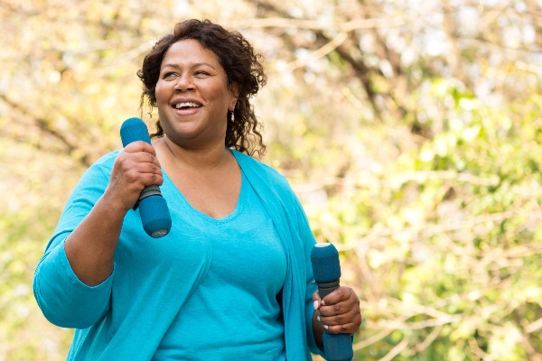 Woman holding dumbell weights while walking outside