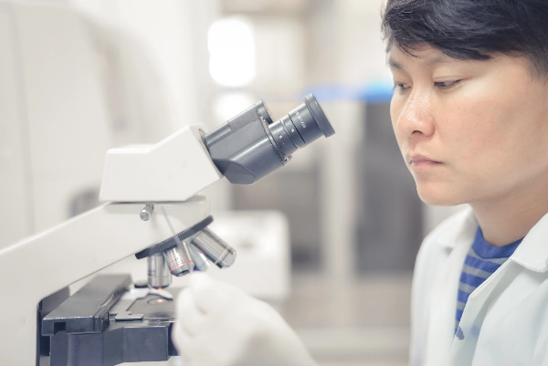 Man using a microscope to examine a sample.