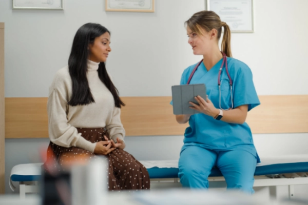 Woman talking with her gynecologist in an exam room.