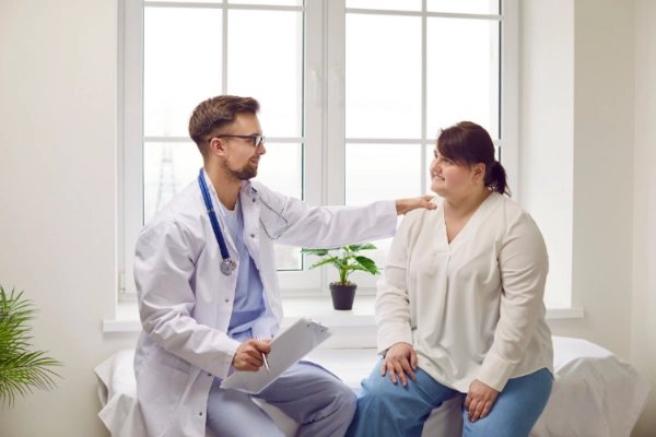 Woman talking with her doctor about cervical cancer screening in an exam room.