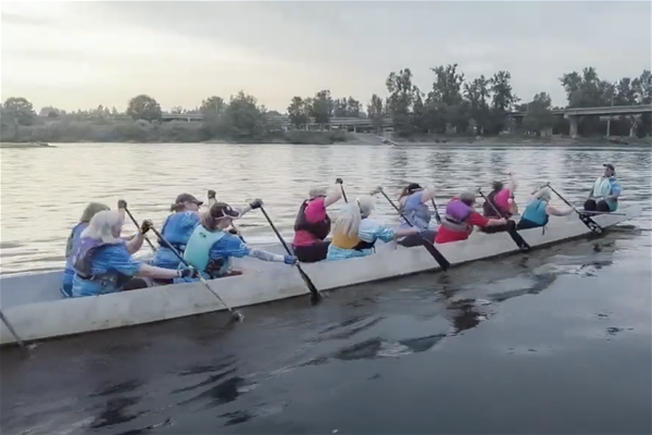 Unsinkables dragon boat team rowing on river