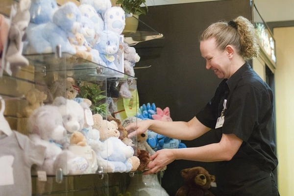 Retail associate arranges gifts.