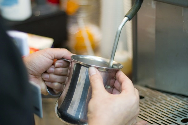 Barista steams milk.