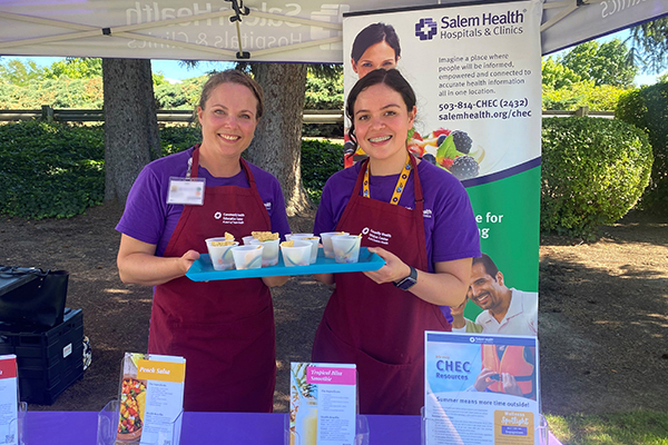 Two Salem Health CHEC staffers serve health snacks at community event.