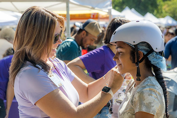 Staff helping young girl with her helmet