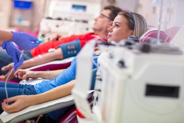 Men and women donate blood plasma in a hospital blood drive.