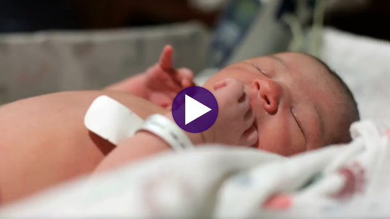 A newborn baby resting in a hospital room.