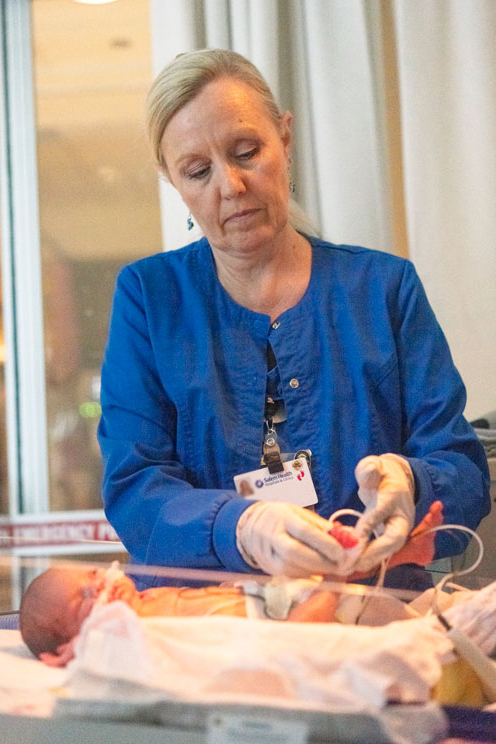 A nurse checks on her patient