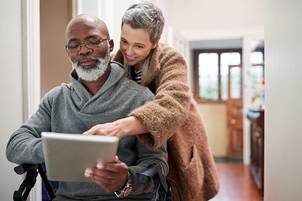 Cropped shot of an affectionate senior couple using a tablet at home with the man sitting in a wheelchair.