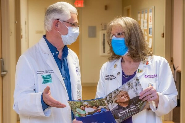 Two cardiac nurse navigators talking in a hallway at the hospital.