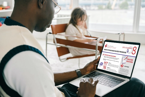 Man reading document about managing blood pressure on his laptop