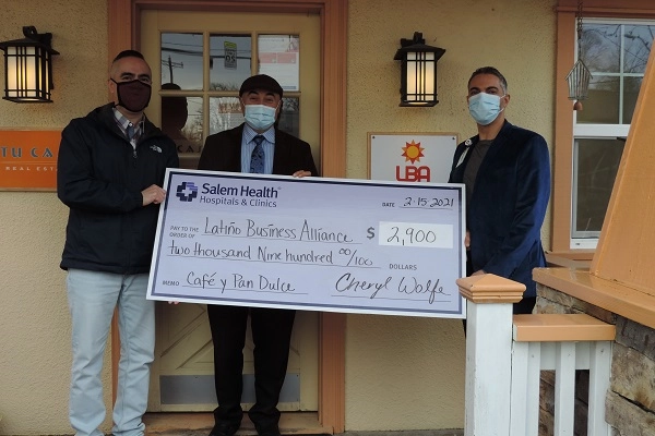 Representatives from the Latino Business Alliance accept a giant novelty check from Bahaa Wanly, Salem Health COO.