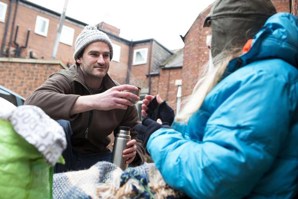 man-offering-hot-drink-from-flask-to-homeless-man_web_1600x1067_color