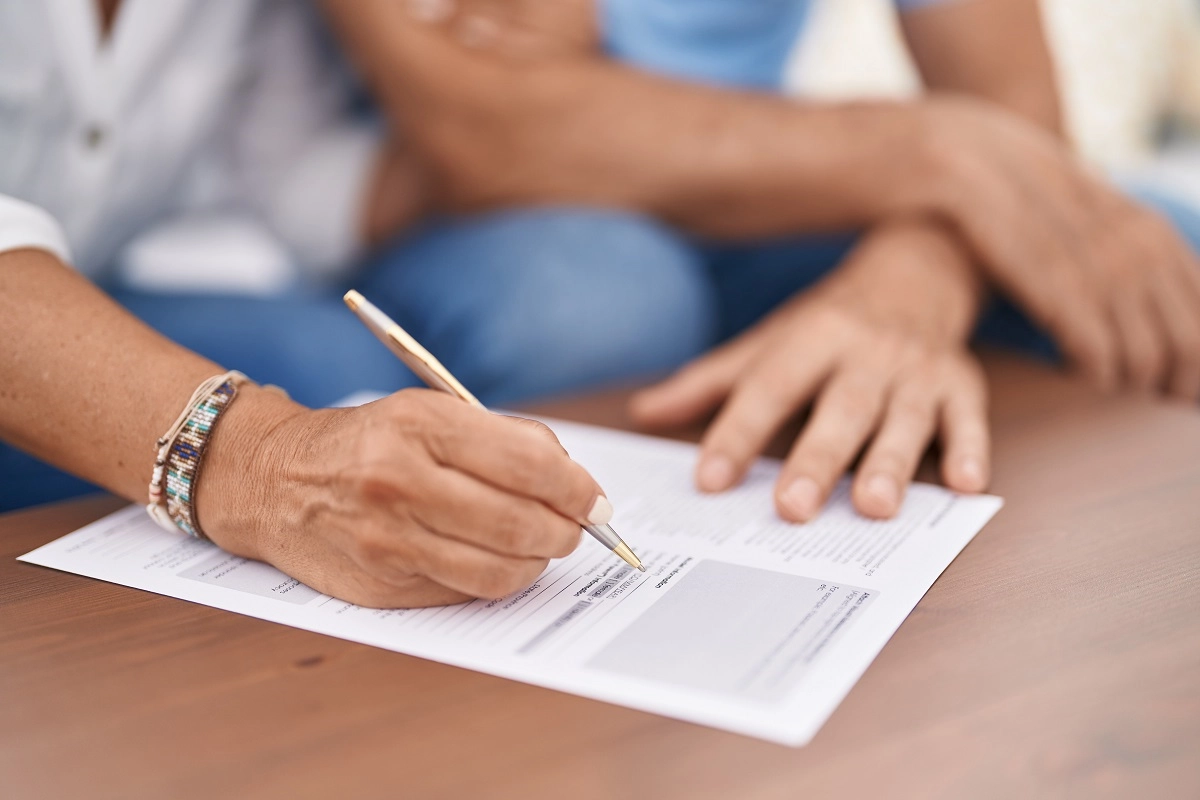hispanic or native american couple filling out a paper form together at home