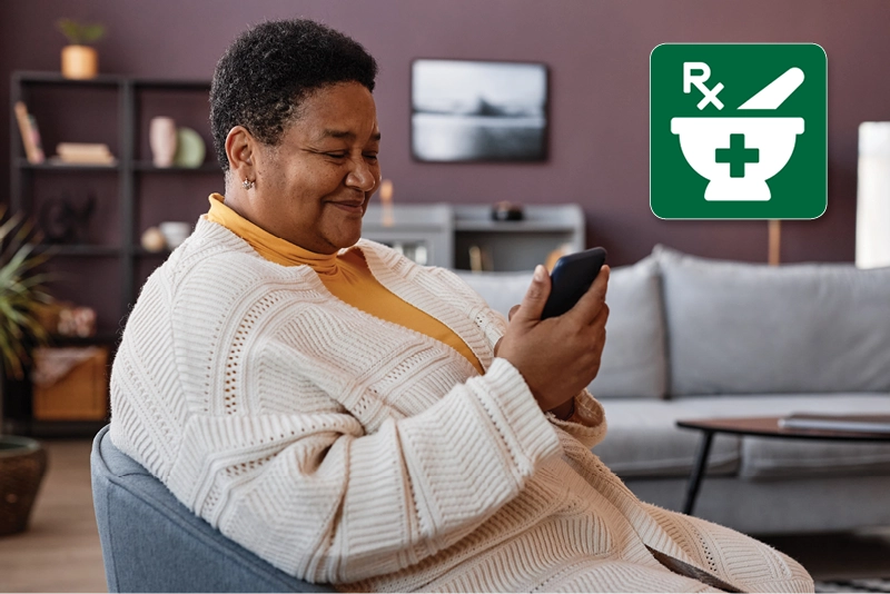 An elderly African American woman looks at her mobile phone.