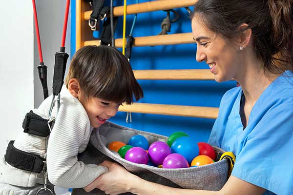 Child working with a caring rehab therapist