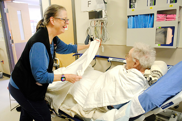 Volunteer helps patient in emergency room