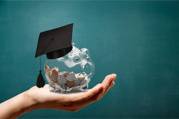 An illustration of a hand holding a piggy bank wearing a mortarboard.